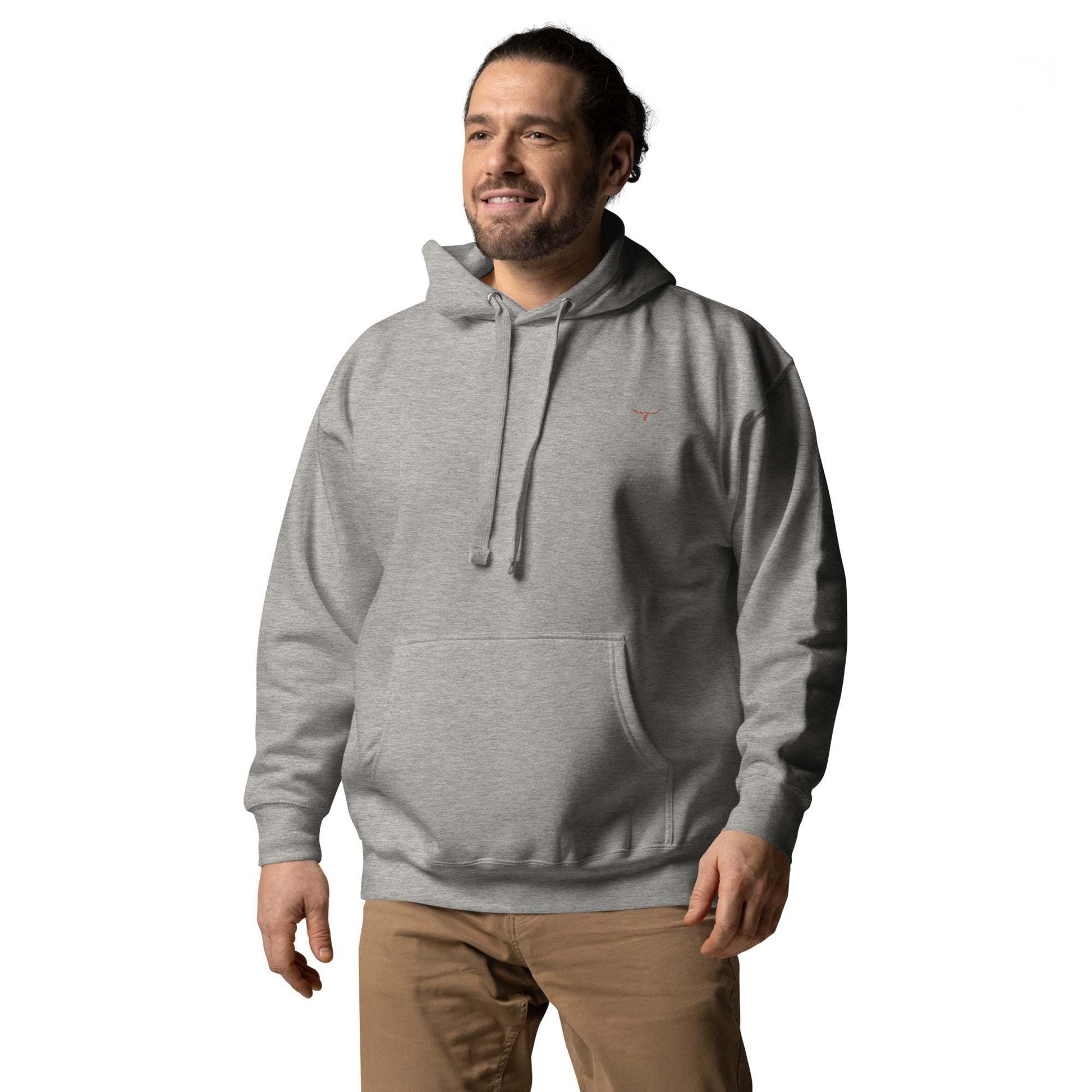 Unisex model wearing a gray Long Horn Skull embroidered hoodie with pouch pocket and drawstrings.